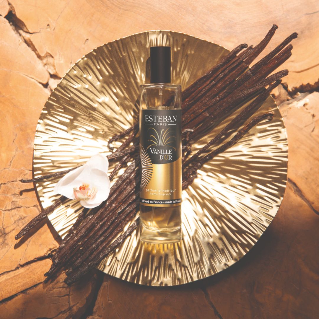 Parfum d’intérieur Esteban Paris Vanille d’Or en spray, flacon vaporisateur présenté sur un plateau doré avec gousses de vanille et orchidée blanche dans une ambiance chaleureuse et raffinée